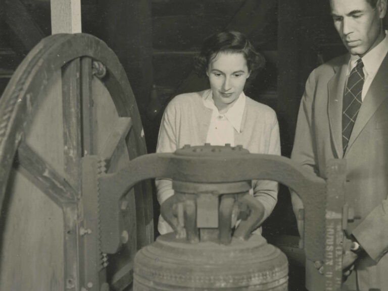 Helen and Harrison Kitzmiller next to the Wester Souburg bell in the WRA chapel, ca. 1944